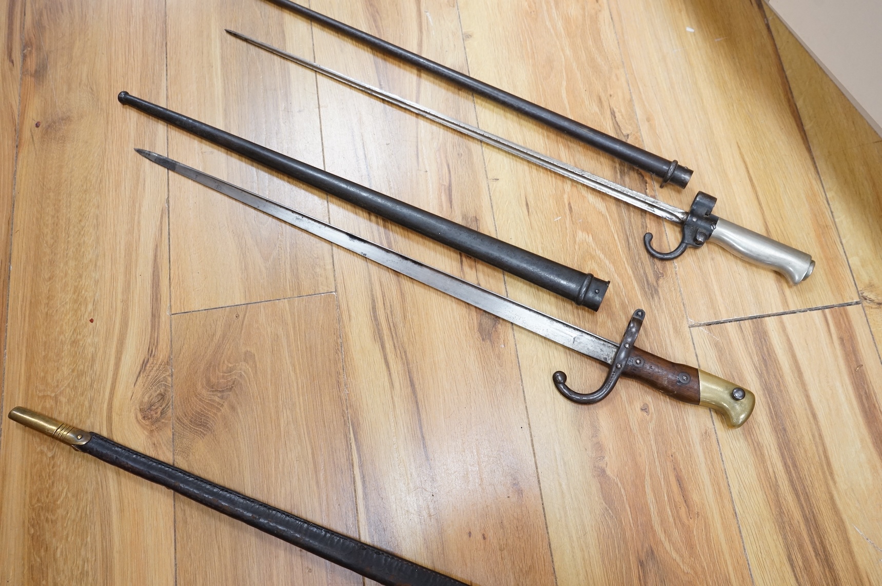 Three bayonets; a gras bayonet, a Lebel bayonet and an Indian Enfield style triangular socket bayonet, all in the original scabbards